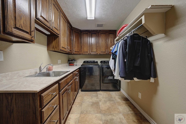 laundry room featuring cabinets, sink, a textured ceiling, and independent washer and dryer