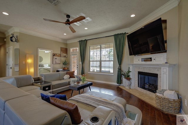 living room featuring crown molding, hardwood / wood-style flooring, ceiling fan, and a high end fireplace