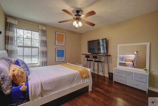 bedroom featuring ceiling fan, a textured ceiling, and dark hardwood / wood-style flooring