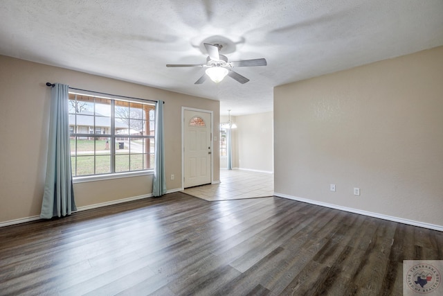 spare room with hardwood / wood-style flooring, ceiling fan with notable chandelier, and a textured ceiling