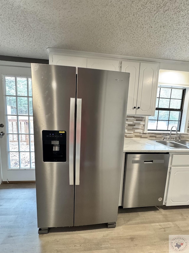 kitchen featuring decorative backsplash, sink, white cabinetry, and stainless steel appliances