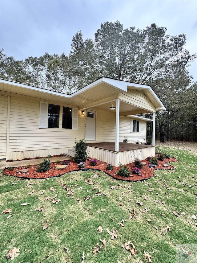 view of front of home with covered porch and a front lawn