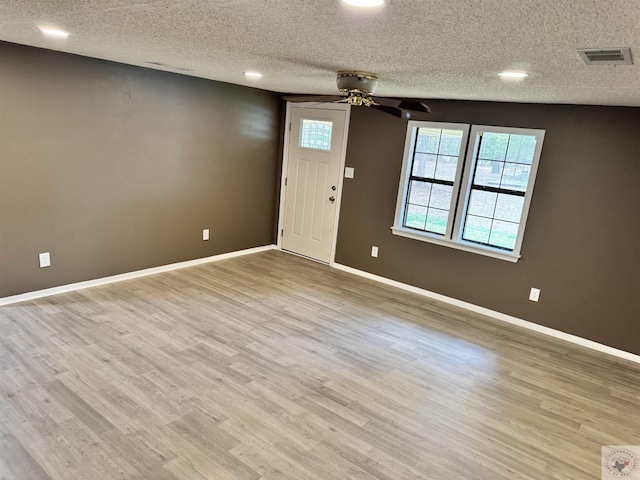 foyer entrance featuring ceiling fan, light hardwood / wood-style floors, and a textured ceiling