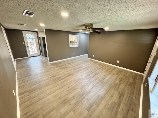 unfurnished room featuring ceiling fan, a textured ceiling, and light wood-type flooring