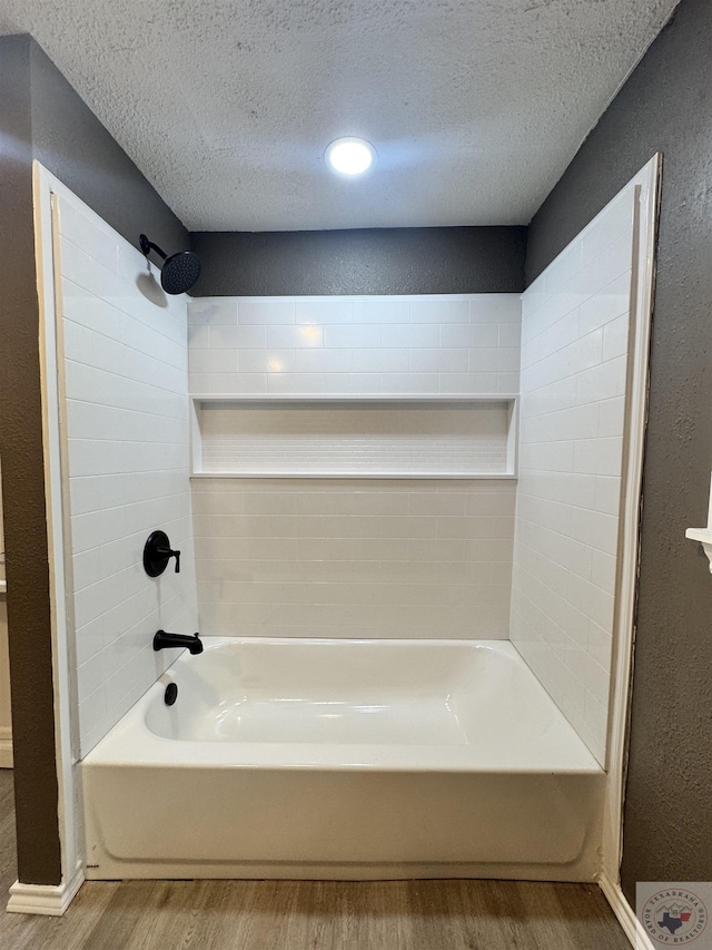 bathroom with  shower combination, a textured ceiling, and wood-type flooring