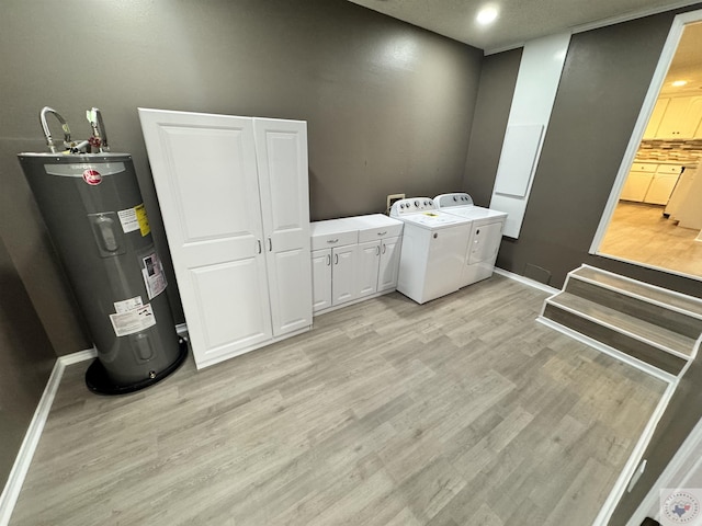 laundry area with independent washer and dryer, light hardwood / wood-style floors, cabinets, and water heater