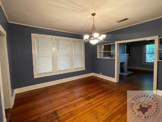 unfurnished dining area with an inviting chandelier, crown molding, and dark hardwood / wood-style flooring