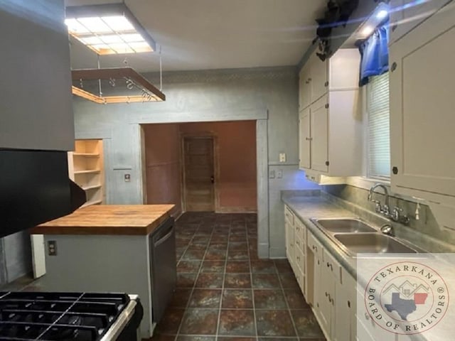 kitchen featuring white cabinets, gas stove, and sink