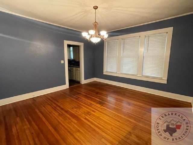 unfurnished room featuring wood-type flooring and a chandelier