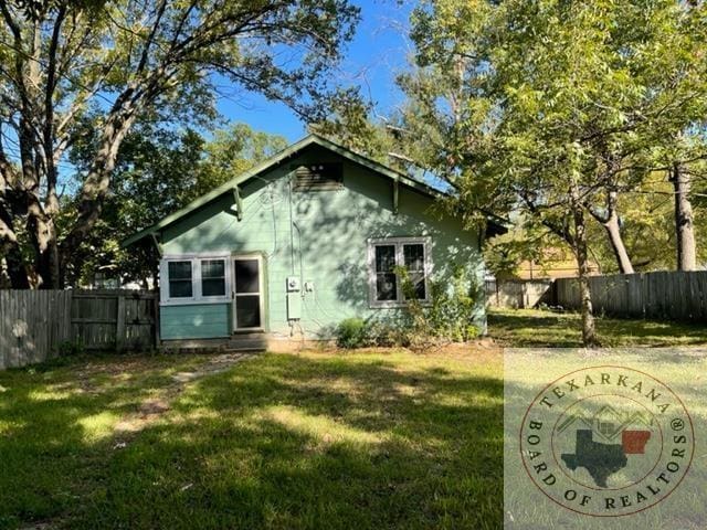 back of house with a lawn