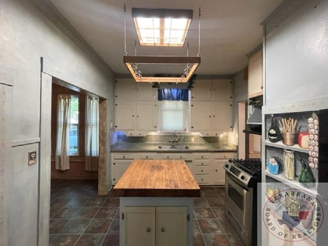 kitchen with sink, white cabinetry, butcher block countertops, a center island, and gas stove