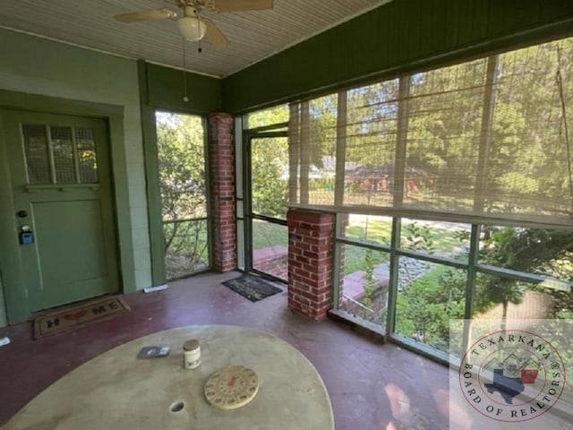 unfurnished sunroom featuring ceiling fan and a healthy amount of sunlight