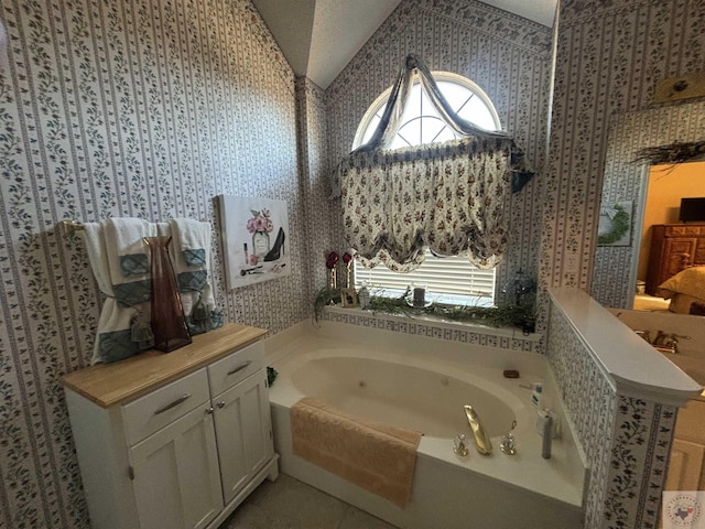 bathroom featuring plenty of natural light, tile patterned floors, a bathing tub, and vaulted ceiling