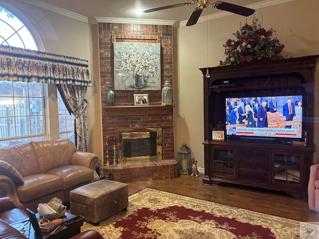 living room featuring ceiling fan, a brick fireplace, ornamental molding, and wood-type flooring