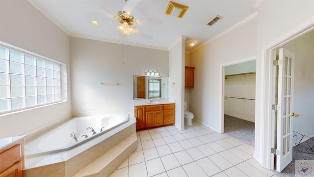 bathroom with crown molding, tile patterned flooring, toilet, a relaxing tiled tub, and vanity