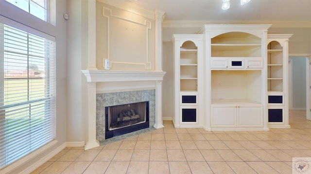 unfurnished living room with a fireplace, built in features, light tile patterned floors, and ornamental molding