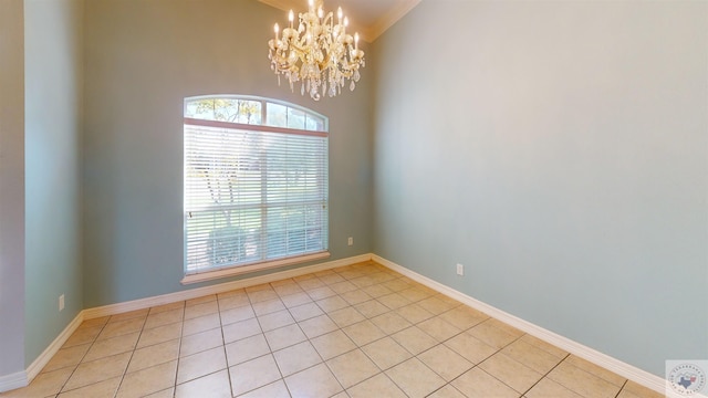 spare room featuring a wealth of natural light, a chandelier, and light tile patterned flooring