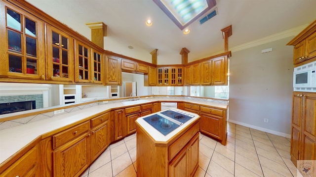 kitchen with white microwave, a kitchen island, electric stovetop, and kitchen peninsula