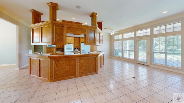 kitchen featuring kitchen peninsula, light tile patterned floors, and ornamental molding