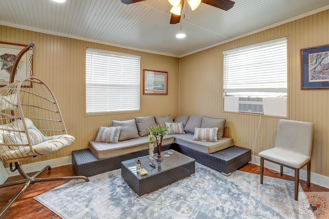 living room featuring wood-type flooring, cooling unit, ceiling fan, and crown molding