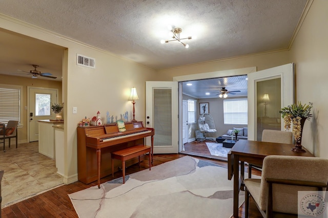 miscellaneous room with ornamental molding, hardwood / wood-style floors, and a textured ceiling