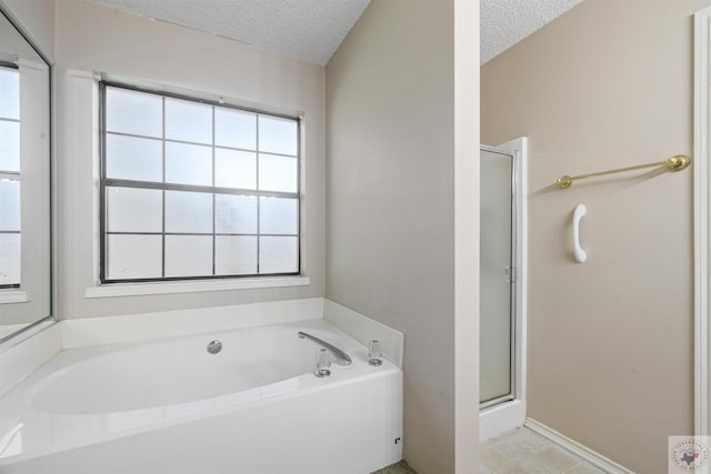 bathroom featuring a textured ceiling, separate shower and tub, and a healthy amount of sunlight