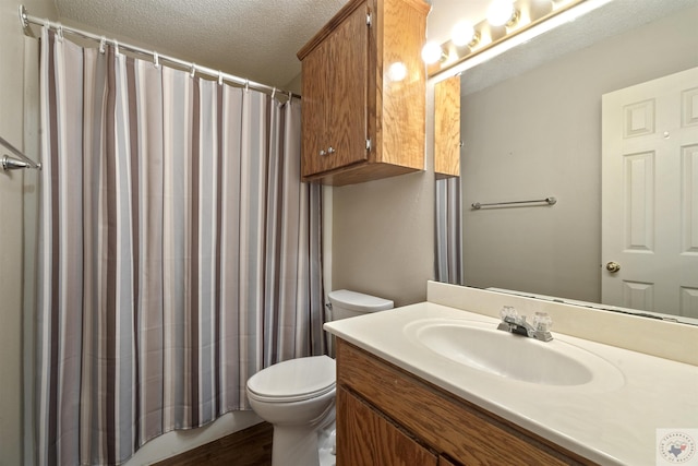 bathroom featuring curtained shower, a textured ceiling, toilet, and vanity