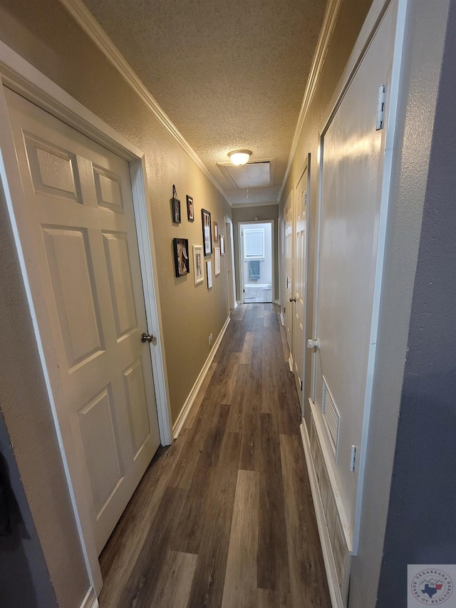 corridor with a textured ceiling, dark hardwood / wood-style flooring, and ornamental molding