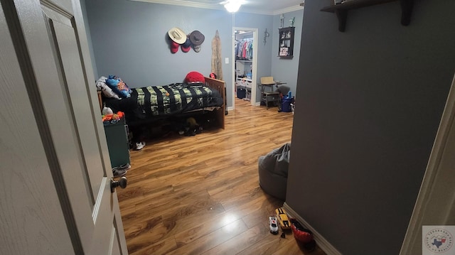 bedroom featuring crown molding and wood-type flooring