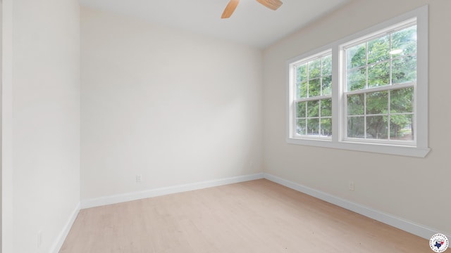 empty room with light wood finished floors, baseboards, and ceiling fan