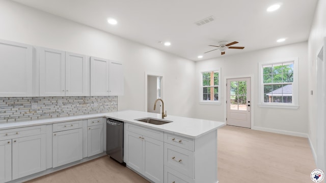 kitchen with a sink, dishwasher, ceiling fan, a peninsula, and visible vents