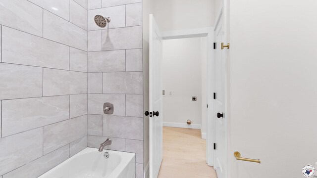 full bathroom with wood finished floors, baseboards, and bathing tub / shower combination