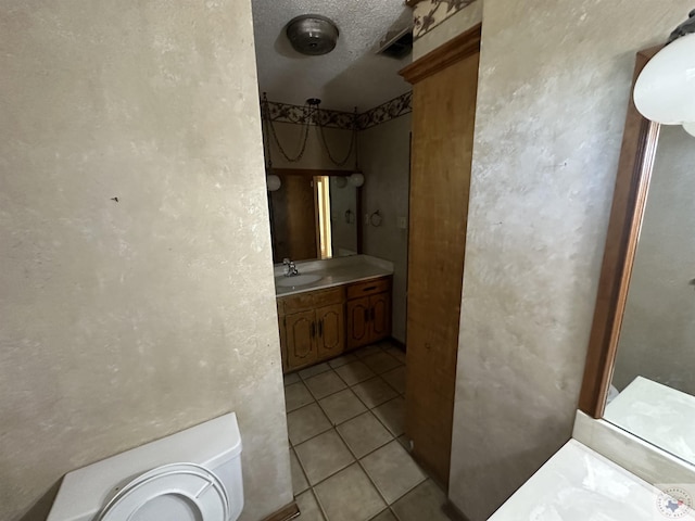 bathroom featuring a textured ceiling, tile patterned floors, vanity, ornate columns, and toilet