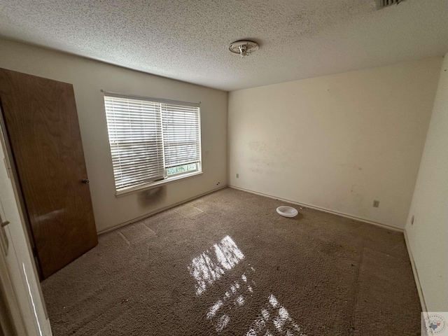 unfurnished room featuring light colored carpet and a textured ceiling