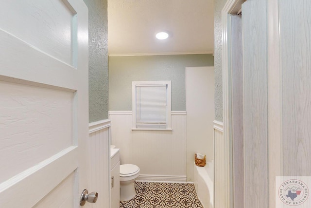 bathroom with crown molding, tile patterned floors, toilet, a bathing tub, and vanity