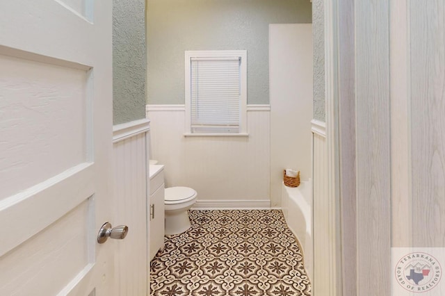 bathroom featuring vanity, toilet, tile patterned floors, and a bathing tub