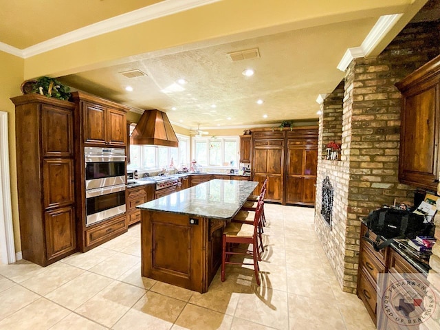 kitchen featuring custom exhaust hood, visible vents, stainless steel double oven, and crown molding