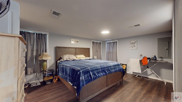 bedroom with dark wood-type flooring and electric panel