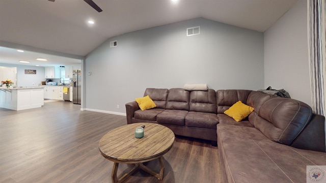 living room with sink, ceiling fan, vaulted ceiling, and wood-type flooring