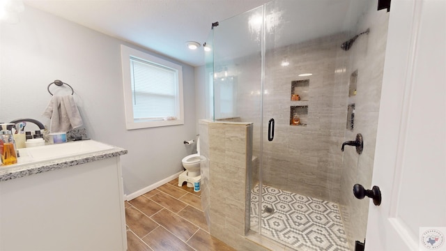 bathroom with an enclosed shower, vanity, and toilet