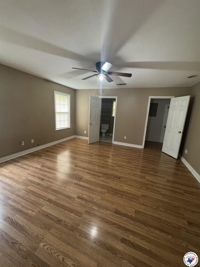 11 Quail Creek Dr, Fouke, AR 71837 - unfurnished bedroom featuring wood finished floors, baseboards, a textured ceiling, connected bathroom, and a ceiling fan