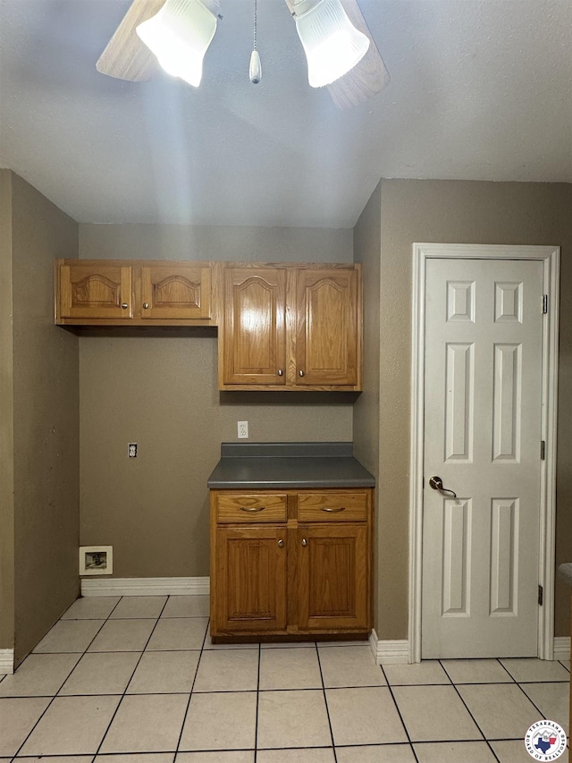 11 Quail Creek Dr, Fouke, AR 71837 - kitchen with light tile patterned floors, dark countertops, baseboards, and brown cabinetry