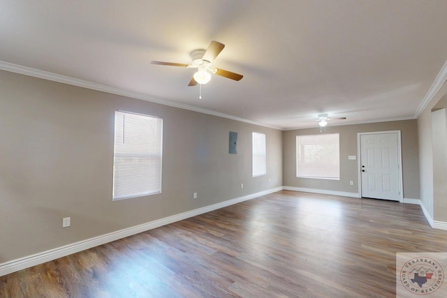 spare room with crown molding, baseboards, and wood finished floors