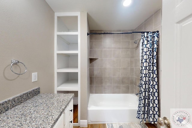 full bathroom featuring built in features, vanity, and shower / tub combo