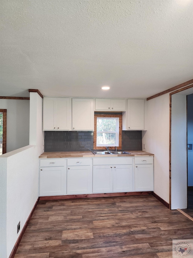 kitchen featuring decorative backsplash, sink, white cabinetry, and dark hardwood / wood-style floors