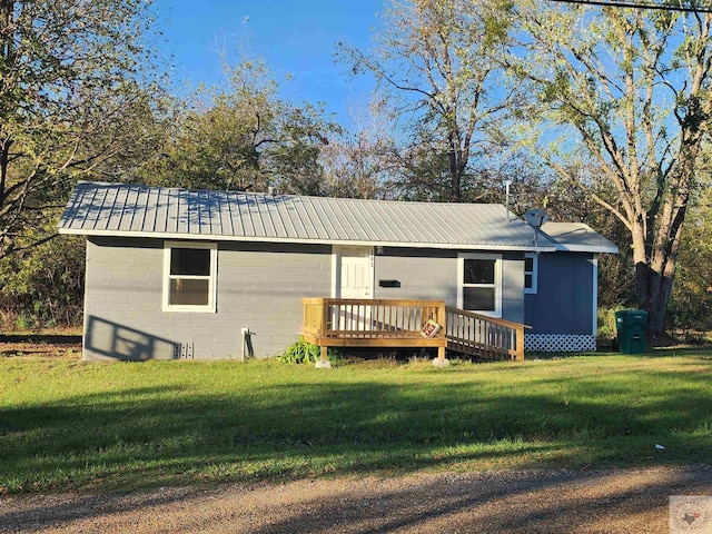 back of house with a wooden deck and a lawn