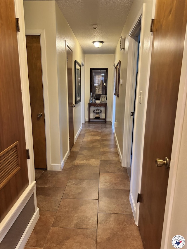 3905 Colorado St, Texarkana, TX 75503 - hall featuring baseboards, a textured ceiling, and tile patterned floors