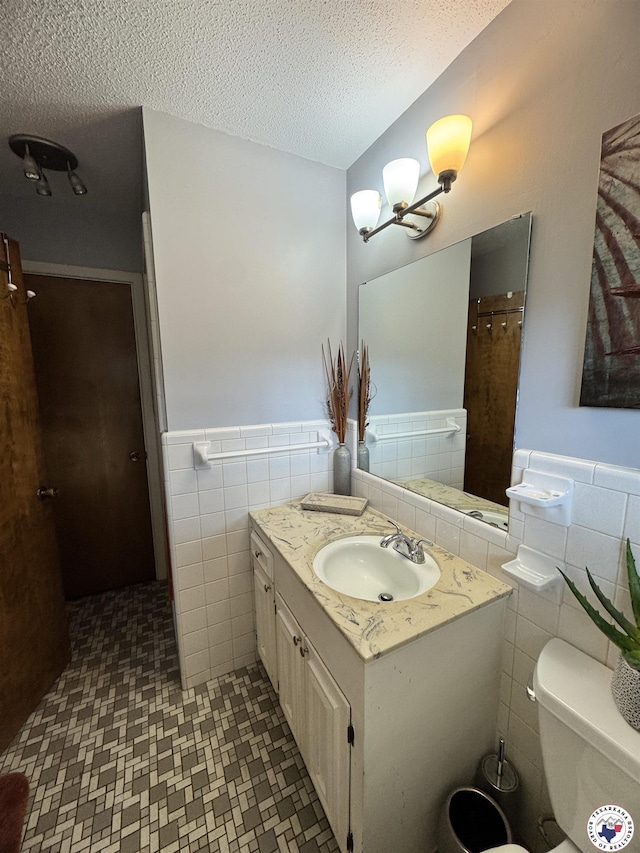 3905 Colorado St, Texarkana, TX 75503 - full bath with tile walls, vanity, a wainscoted wall, a textured ceiling, and a chandelier