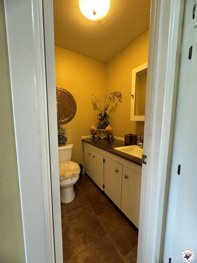 3905 Colorado St, Texarkana, TX 75503 - half bath featuring toilet, vanity, a textured ceiling, and tile patterned flooring