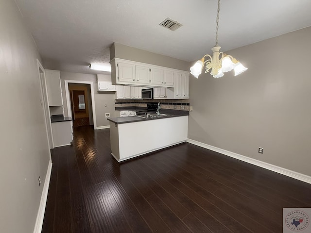 kitchen featuring kitchen peninsula, pendant lighting, dark hardwood / wood-style flooring, white cabinets, and a notable chandelier